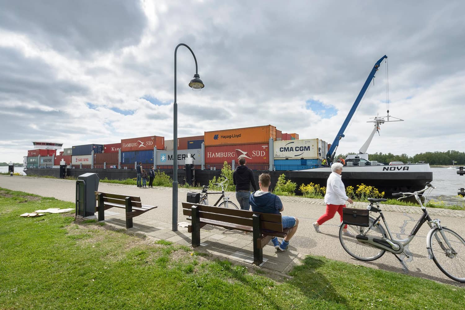 Containerschip de NOVA onderweg varend van Duitsland naar de haven van Antwerpen, mensen aan de wal kijken toe.