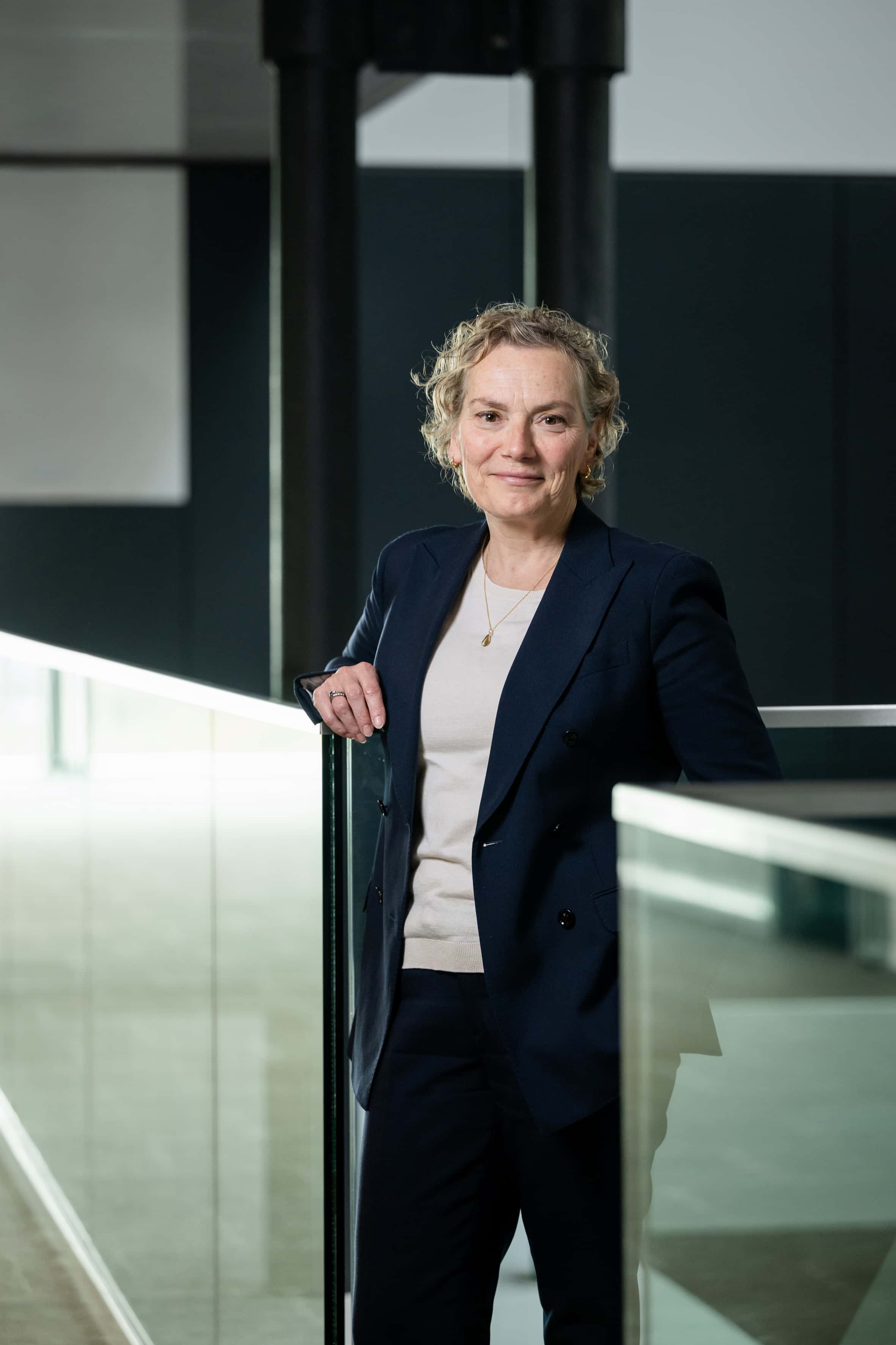 Petra lugtenburg staand bij een trap op het ministerie van IenW.