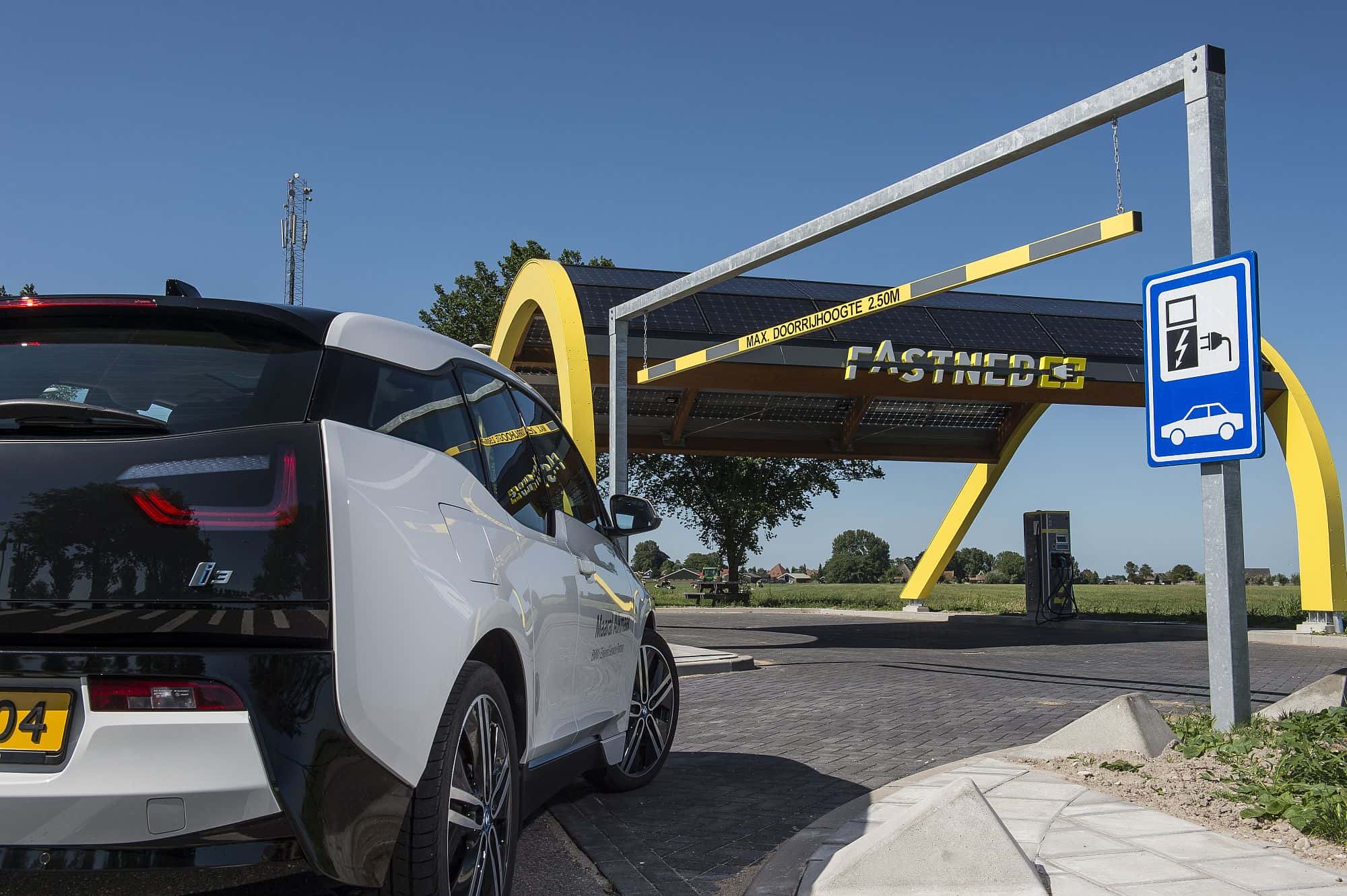 Elektrische personenauto (BMW i3) rijdt naar het snellaadstation van Fastned De Horn langs de A7 bij Abbekerk om de accu op te laden.
