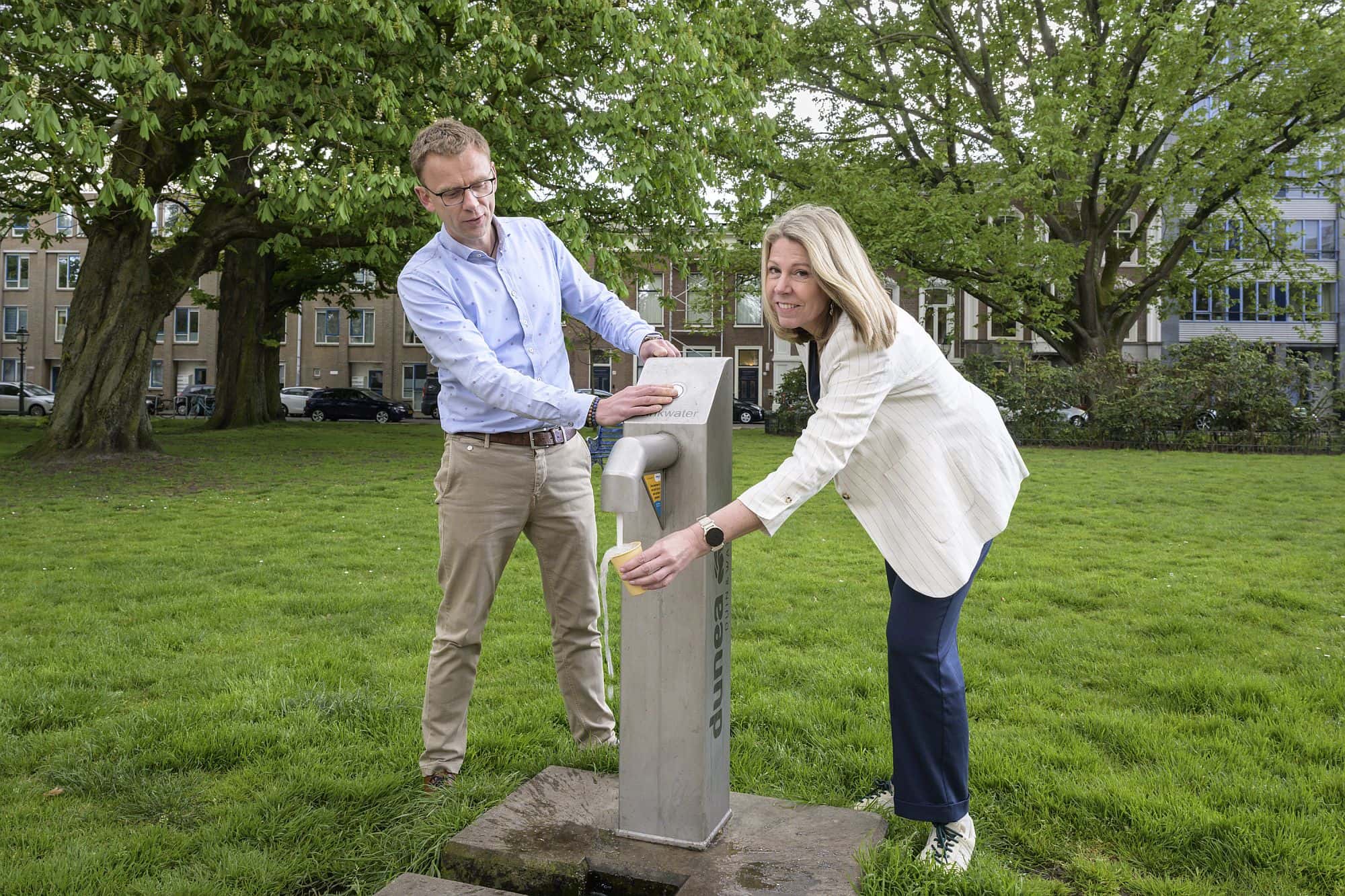Sjoerd Steenbergen en Marie-José Schoonens bij een buitenkraan voor drinkwater in een plantsoen